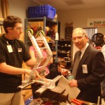 Students showing Mr. Kennedy the bridge-lowering mechanism prototype.